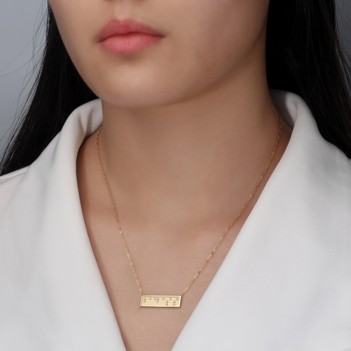 badass braille necklace on model by Touchstone